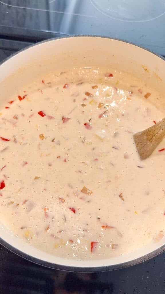 stirring potatoes and corn into creamy chicken soup