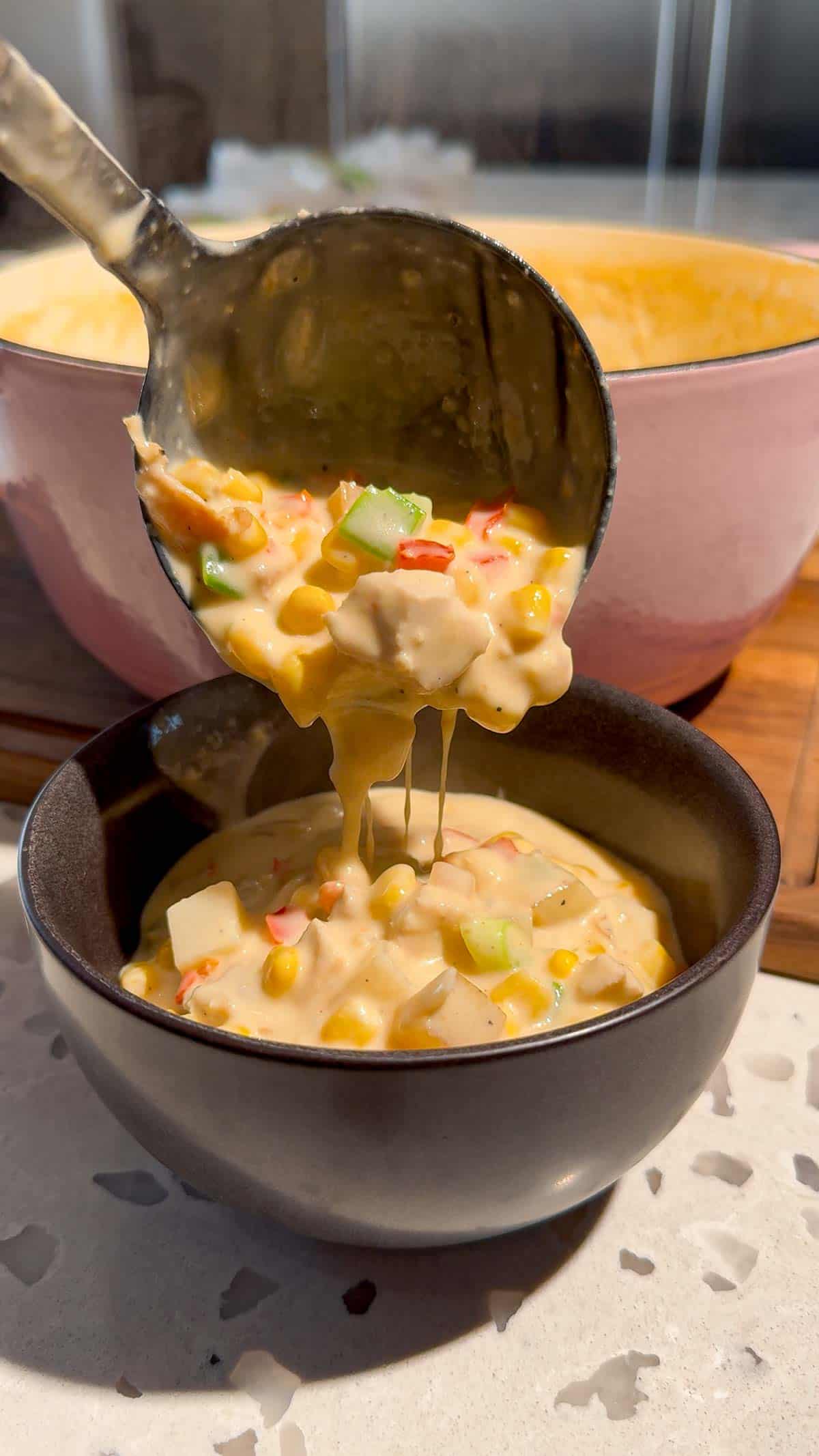 ladling chicken corn chowder into a bowl