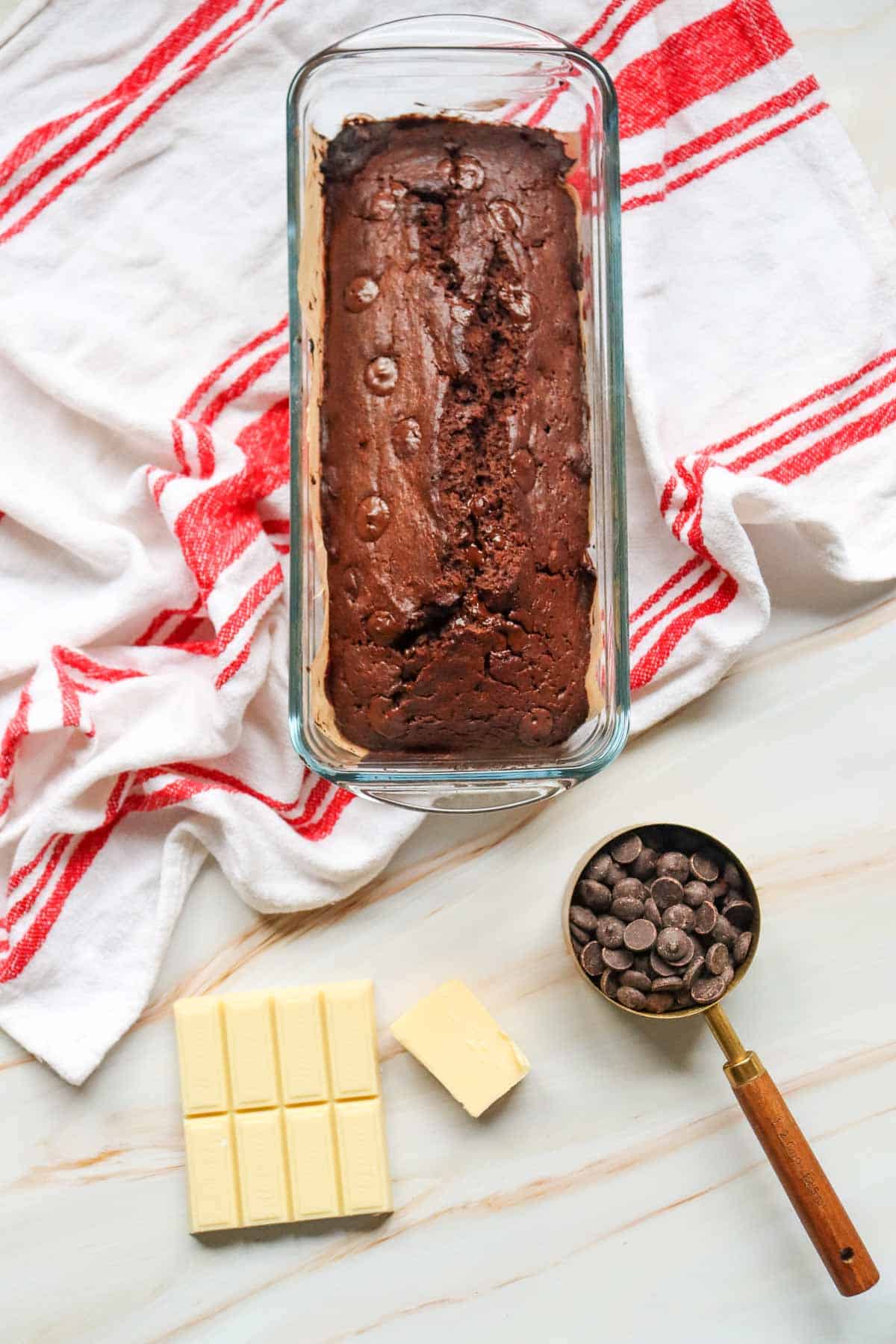 This Chocolate Loaf Cake is a rich, moist and decadent dessert that's perfect for chocolate lovers! This easy Chocolate Loaf Cake Recipe is made with cocoa powder, buttermilk and dark chocolate chips for a soft, tender crumb packed with chocolate flavor. Topped with a dark chocolate and white chocolate drizzle, this homemade chocolate bread makes an impressive but simple dessert for any occasion. If you're looking for Easy Loaf Cake Recipes, Chocolate Dessert Recipes, Chocolate Bread Recipes, Easy Baking Recipes or a Moist Chocolate Cake Recipe, this one belongs on your baking list. Serve this Chocolate Chip Loaf Cake for birthdays, holidays, afternoon treats, brunch or dessert. It's an easy chocolate cake that's delicious with coffee, tea or a glass of milk and perfect for sharing!