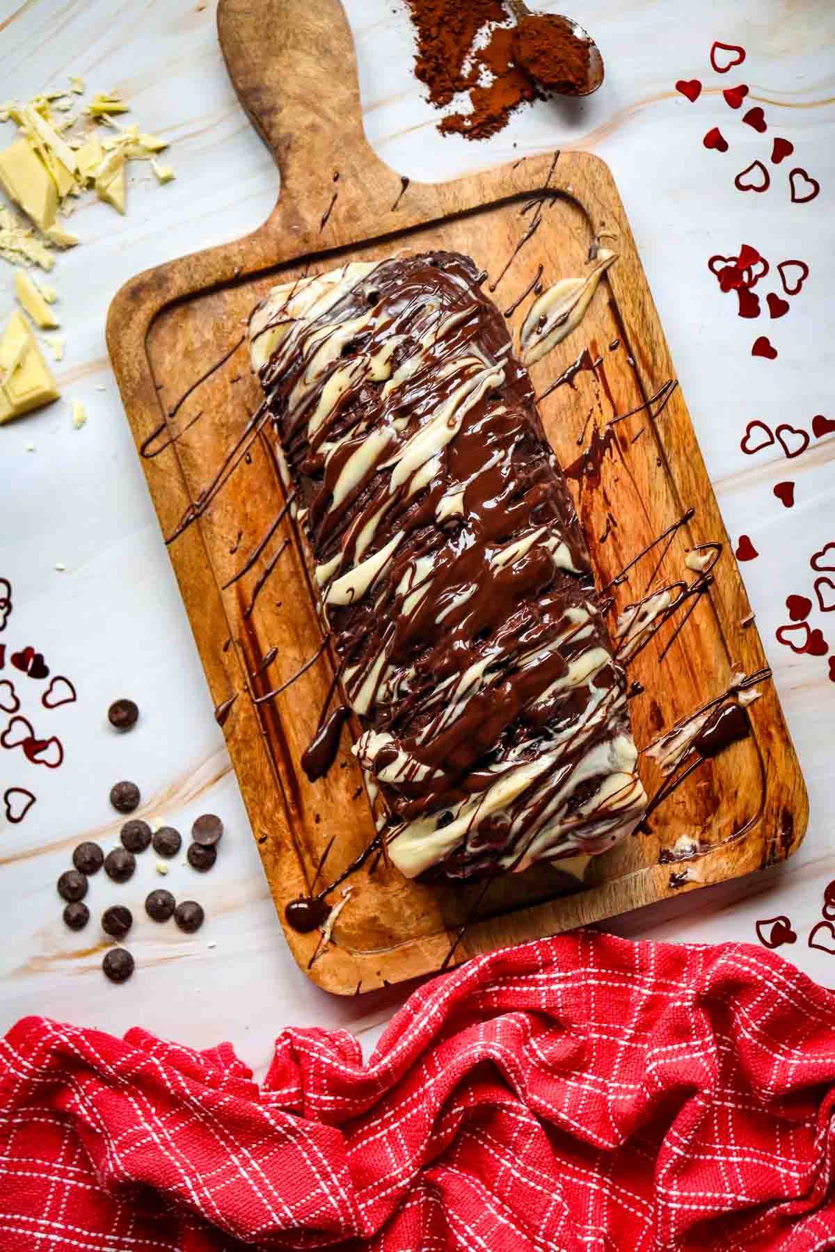 This Chocolate Loaf Cake is a rich, moist and decadent dessert that's perfect for chocolate lovers! This easy Chocolate Loaf Cake Recipe is made with cocoa powder, buttermilk and dark chocolate chips for a soft, tender crumb packed with chocolate flavor. Topped with a dark chocolate and white chocolate drizzle, this homemade chocolate bread makes an impressive but simple dessert for any occasion. If you're looking for Easy Loaf Cake Recipes, Chocolate Dessert Recipes, Chocolate Bread Recipes, Easy Baking Recipes or a Moist Chocolate Cake Recipe, this one belongs on your baking list. Serve this Chocolate Chip Loaf Cake for birthdays, holidays, afternoon treats, brunch or dessert. It's an easy chocolate cake that's delicious with coffee, tea or a glass of milk and perfect for sharing!
