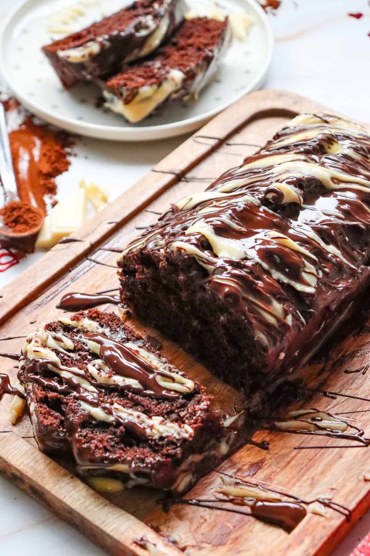 This Chocolate Loaf Cake is a rich, moist and decadent dessert that's perfect for chocolate lovers! This easy Chocolate Loaf Cake Recipe is made with cocoa powder, buttermilk and dark chocolate chips for a soft, tender crumb packed with chocolate flavor. Topped with a dark chocolate and white chocolate drizzle, this homemade chocolate bread makes an impressive but simple dessert for any occasion. If you're looking for Easy Loaf Cake Recipes, Chocolate Dessert Recipes, Chocolate Bread Recipes, Easy Baking Recipes or a Moist Chocolate Cake Recipe, this one belongs on your baking list. Serve this Chocolate Chip Loaf Cake for birthdays, holidays, afternoon treats, brunch or dessert. It's an easy chocolate cake that's delicious with coffee, tea or a glass of milk and perfect for sharing!