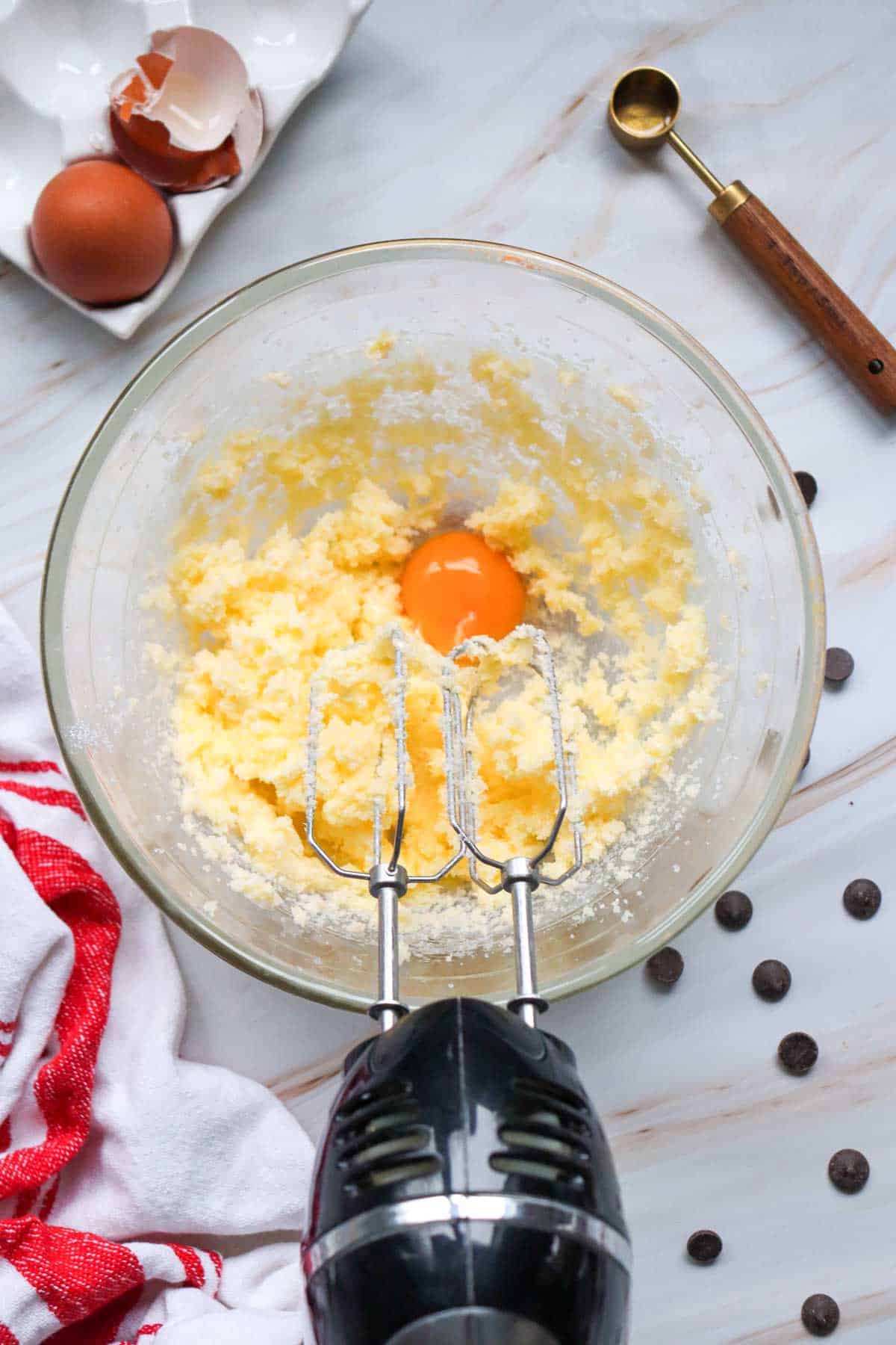 adding eggs to bowl with butter and sugar mixture