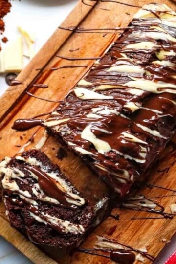 This Chocolate Loaf Cake is a rich, moist and decadent dessert that's perfect for chocolate lovers! This easy Chocolate Loaf Cake Recipe is made with cocoa powder, buttermilk and dark chocolate chips for a soft, tender crumb packed with chocolate flavor. Topped with a dark chocolate and white chocolate drizzle, this homemade chocolate bread makes an impressive but simple dessert for any occasion. If you're looking for Easy Loaf Cake Recipes, Chocolate Dessert Recipes, Chocolate Bread Recipes, Easy Baking Recipes or a Moist Chocolate Cake Recipe, this one belongs on your baking list. Serve this Chocolate Chip Loaf Cake for birthdays, holidays, afternoon treats, brunch or dessert. It's an easy chocolate cake that's delicious with coffee, tea or a glass of milk and perfect for sharing!