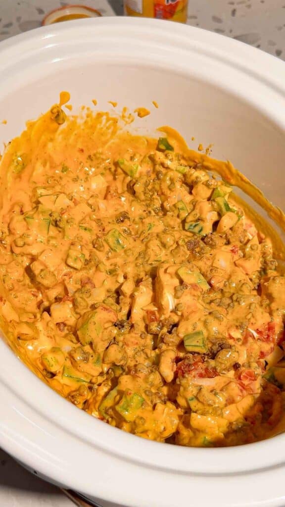 stirred nacho ingredients in a crock pot before cooking