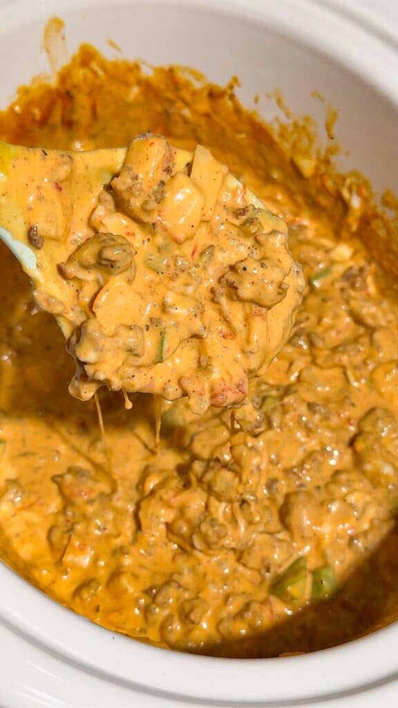 These Crock Pot Nachos are easy game day food, party appetizer or fun family dinner loaded with bold Tex-Mex flavor. This easy slow cooker nachos recipe combines seasoned ground beef, Italian sausage, onions, green peppers, Rotel, salsa con queso, cream cheese and shredded cheese for an extra creamy, meaty nacho topping. Spoon the cheesy Crock Pot nacho mixture over tortilla chips or Doritos, then add sour cream, guacamole, diced tomatoes, cilantro and jalapenos. If you need easy Crock Pot appetizers, slow cooker party food, football food ideas, Super Bowl snacks, nacho recipes or easy appetizers for a crowd, save this recipe. These loaded nachos are perfect for game day parties, potlucks, movie nights and casual entertaining when you want easy comfort food everyone will dig into!