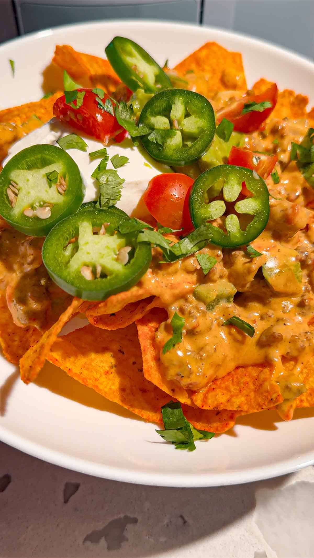 These Crock Pot Nachos are easy game day food, party appetizer or fun family dinner loaded with bold Tex-Mex flavor. This easy slow cooker nachos recipe combines seasoned ground beef, Italian sausage, onions, green peppers, Rotel, salsa con queso, cream cheese and shredded cheese for an extra creamy, meaty nacho topping. Spoon the cheesy Crock Pot nacho mixture over tortilla chips or Doritos, then add sour cream, guacamole, diced tomatoes, cilantro and jalapenos. If you need easy Crock Pot appetizers, slow cooker party food, football food ideas, Super Bowl snacks, nacho recipes or easy appetizers for a crowd, save this recipe. These loaded nachos are perfect for game day parties, potlucks, movie nights and casual entertaining when you want easy comfort food everyone will dig into!