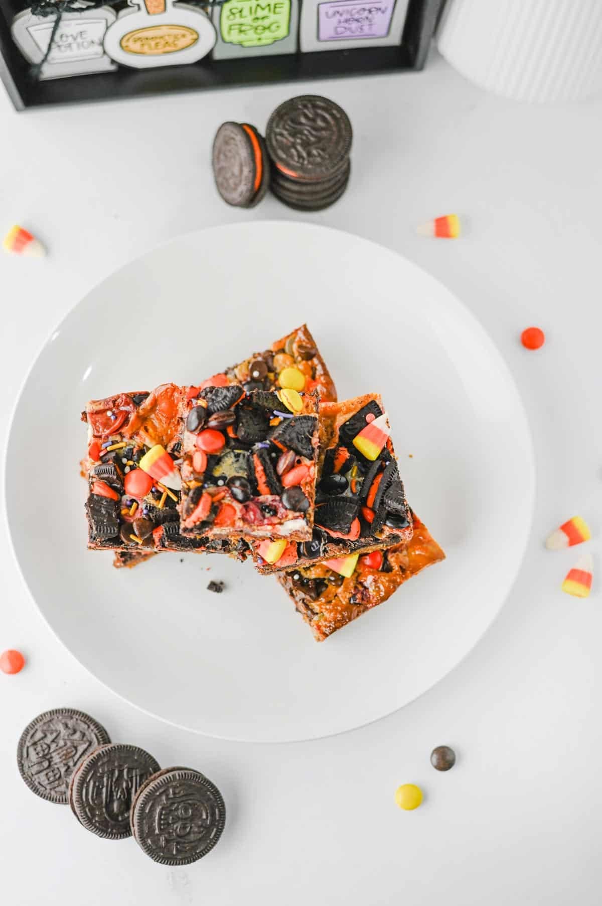 These Halloween Layer Bars are an easy Halloween dessert, loaded with chocolate chip cookie dough, Halloween Oreos, M&Ms, Reese’s Pieces, candy corn and festive sprinkles. If you’re looking for Halloween desserts for a party, Halloween treats for kids, easy Halloween baking ideas or fun Halloween party food, these gooey cookie bars check every box. A buttery chocolate chip cookie base is piled high with crushed Oreos, chocolate candy and sweetened condensed milk for rich, chewy layers in every bite. These Halloween cookie bars are perfect for a Halloween bake sale, classroom party, spooky movie night or October dessert table. Save this Halloween layer bars recipe when you need easy Halloween treats, candy corn desserts, Halloween Oreo desserts or a fun way to use Halloween candy!