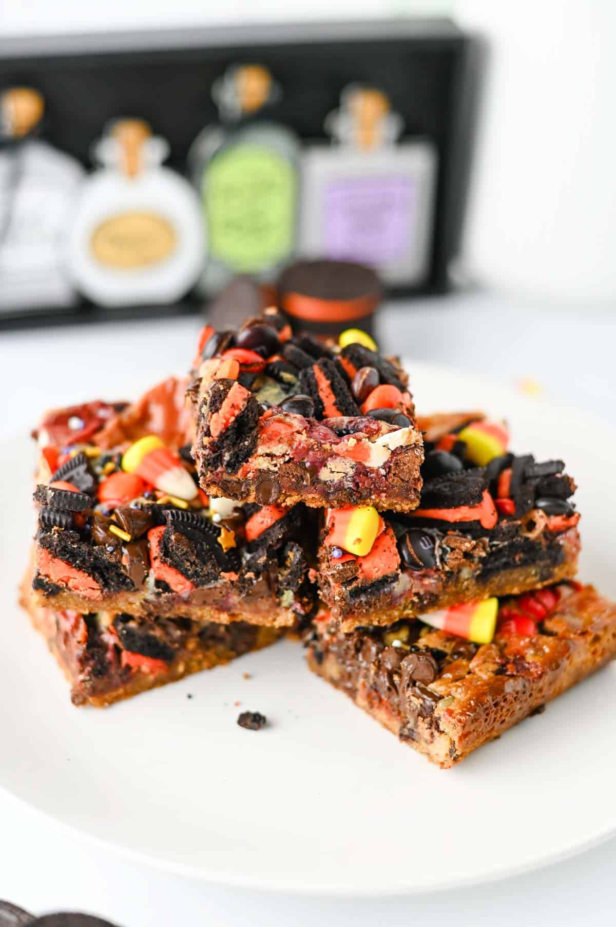 These Halloween Layer Bars are an easy Halloween dessert, loaded with chocolate chip cookie dough, Halloween Oreos, M&Ms, Reese’s Pieces, candy corn and festive sprinkles. If you’re looking for Halloween desserts for a party, Halloween treats for kids, easy Halloween baking ideas or fun Halloween party food, these gooey cookie bars check every box. A buttery chocolate chip cookie base is piled high with crushed Oreos, chocolate candy and sweetened condensed milk for rich, chewy layers in every bite. These Halloween cookie bars are perfect for a Halloween bake sale, classroom party, spooky movie night or October dessert table. Save this Halloween layer bars recipe when you need easy Halloween treats, candy corn desserts, Halloween Oreo desserts or a fun way to use Halloween candy!