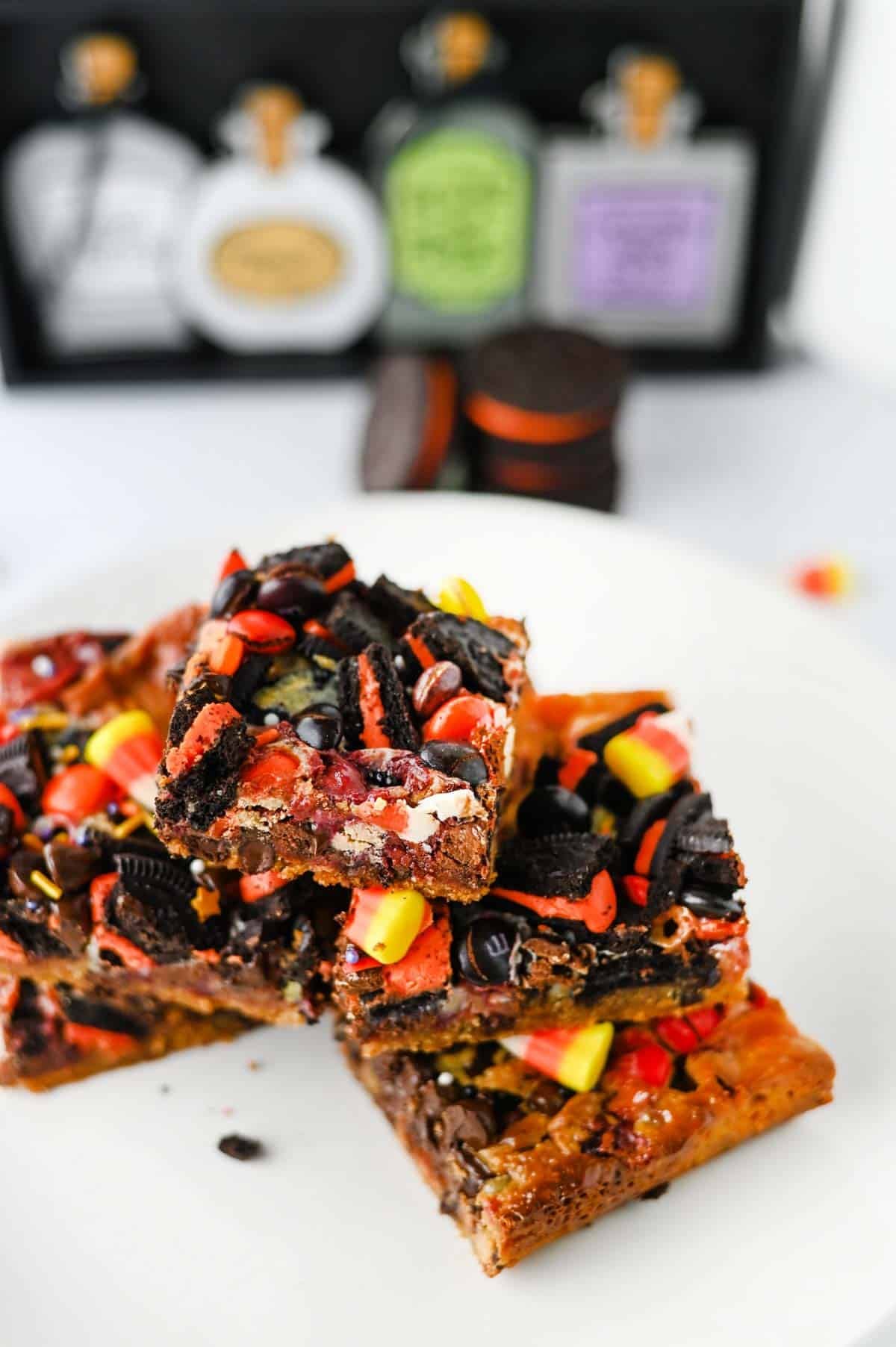 These Halloween Layer Bars are an easy Halloween dessert, loaded with chocolate chip cookie dough, Halloween Oreos, M&Ms, Reese’s Pieces, candy corn and festive sprinkles. If you’re looking for Halloween desserts for a party, Halloween treats for kids, easy Halloween baking ideas or fun Halloween party food, these gooey cookie bars check every box. A buttery chocolate chip cookie base is piled high with crushed Oreos, chocolate candy and sweetened condensed milk for rich, chewy layers in every bite. These Halloween cookie bars are perfect for a Halloween bake sale, classroom party, spooky movie night or October dessert table. Save this Halloween layer bars recipe when you need easy Halloween treats, candy corn desserts, Halloween Oreo desserts or a fun way to use Halloween candy!