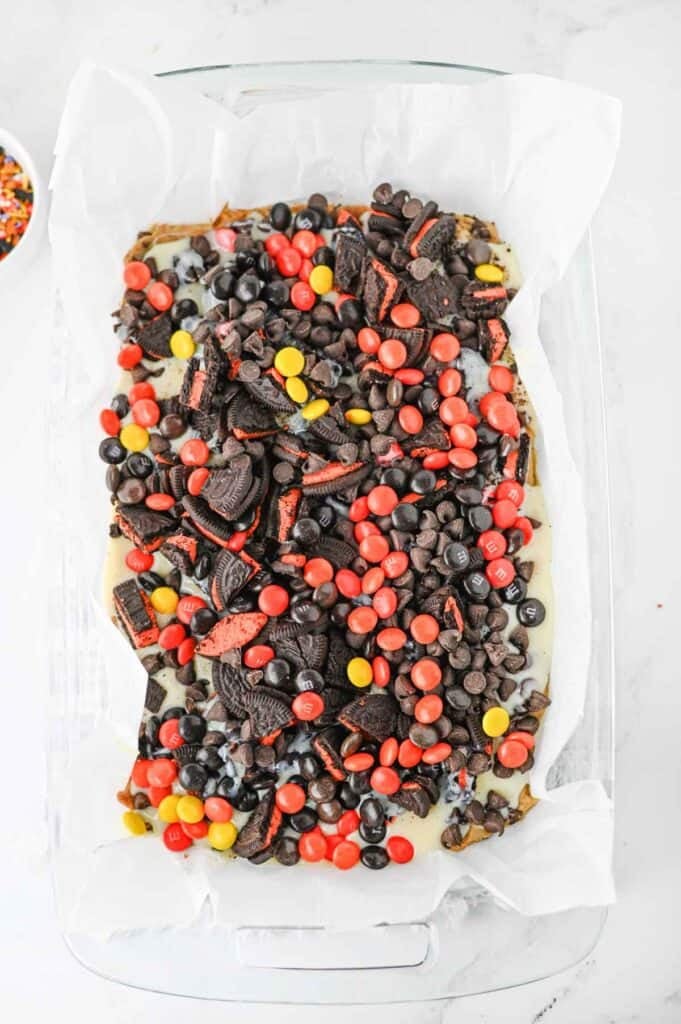 halloween 7 layer bars in a parchment lined baking dish