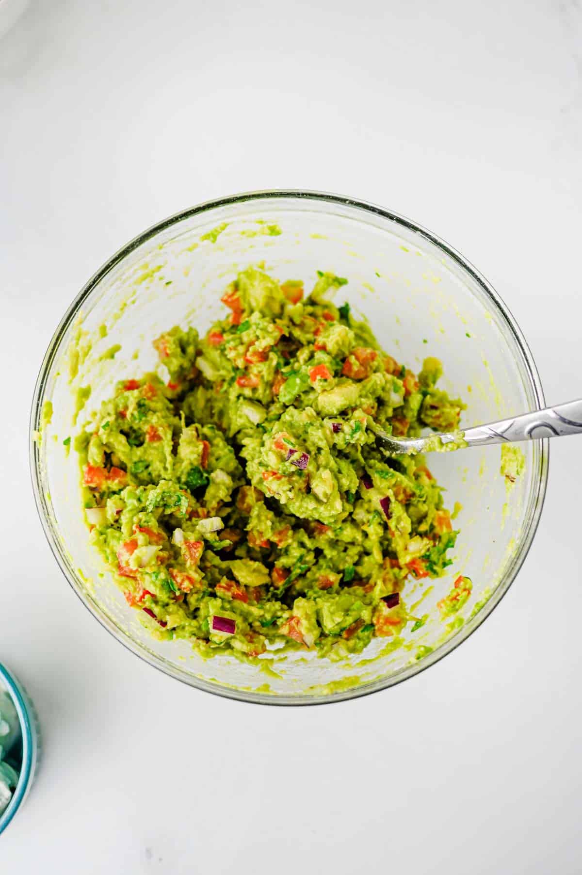 stirring guacamole in a bowl