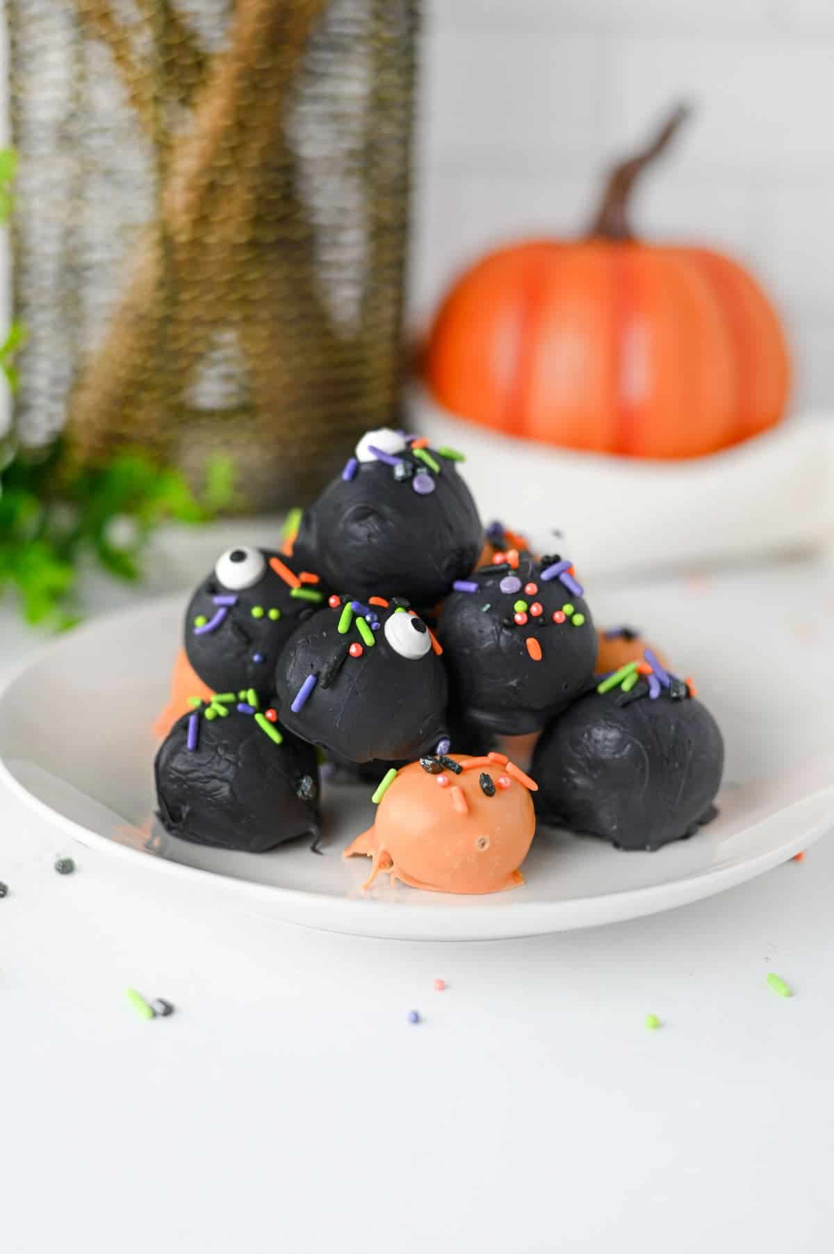 These Halloween Oreo Balls are the ultimate easy no bake Halloween treats for parties and spooky dessert tables! Made with crushed Oreo cookies and cream cheese, these Oreo truffles are dipped in orange and black candy melts and finished with festive Halloween sprinkles. If you're looking for Halloween Oreo balls, Halloween Oreo truffles, easy Halloween desserts, Halloween party food, or fun Halloween treats for kids, this simple recipe is a must-try. They're perfect for Halloween parties, bake sales, potlucks, classroom treats, and movie nights. With just a handful of ingredients and no oven required, these chocolate Oreo balls are an easy Halloween candy treat you can make ahead. Save this Halloween Oreo balls recipe for a spooky and delicious Halloween dessert everyone will love!