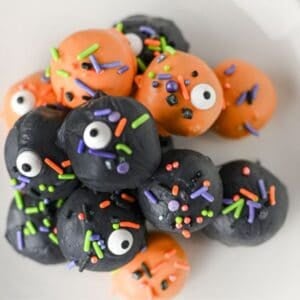 These Halloween Oreo Balls are the ultimate easy no bake Halloween treats for parties and spooky dessert tables! Made with crushed Oreo cookies and cream cheese, these Oreo truffles are dipped in orange and black candy melts and finished with festive Halloween sprinkles. If you're looking for Halloween Oreo balls, Halloween Oreo truffles, easy Halloween desserts, Halloween party food, or fun Halloween treats for kids, this simple recipe is a must-try. They're perfect for Halloween parties, bake sales, potlucks, classroom treats, and movie nights. With just a handful of ingredients and no oven required, these chocolate Oreo balls are an easy Halloween candy treat you can make ahead. Save this Halloween Oreo balls recipe for a spooky and delicious Halloween dessert everyone will love!