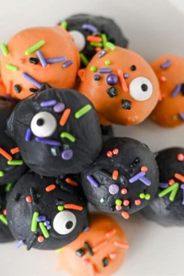 These Halloween Oreo Balls are the ultimate easy no bake Halloween treats for parties and spooky dessert tables! Made with crushed Oreo cookies and cream cheese, these Oreo truffles are dipped in orange and black candy melts and finished with festive Halloween sprinkles. If you're looking for Halloween Oreo balls, Halloween Oreo truffles, easy Halloween desserts, Halloween party food, or fun Halloween treats for kids, this simple recipe is a must-try. They're perfect for Halloween parties, bake sales, potlucks, classroom treats, and movie nights. With just a handful of ingredients and no oven required, these chocolate Oreo balls are an easy Halloween candy treat you can make ahead. Save this Halloween Oreo balls recipe for a spooky and delicious Halloween dessert everyone will love!