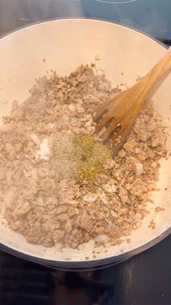 seasonings added to cooked ground meat in a large pot