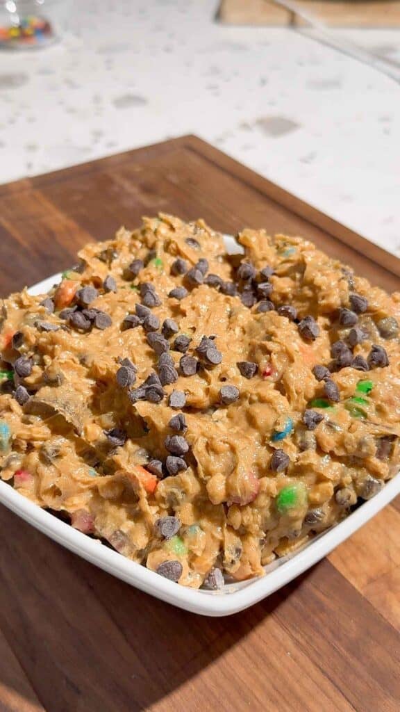 mini chocolate chips on top of peanut butter cookie dough dip in a bowl