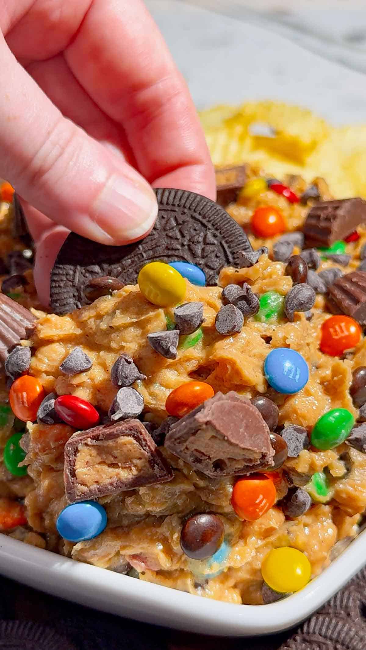 dipping an oreo cookie in monster cookie dough dip