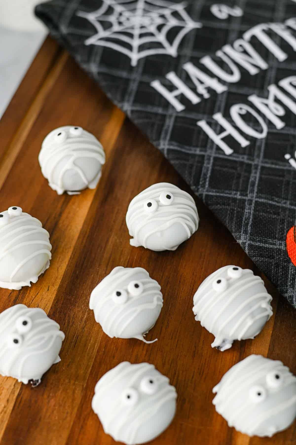 These Mummy Oreo Balls are the ultimate spooky treat for Halloween parties, dessert tables, and school celebrations! Made with crushed Oreo cookies, cream cheese, vanilla almond bark, and candy eyes, this easy Mummy Oreo Balls Recipe is a fun No Bake Halloween Treat that everyone will love. If you're searching for Halloween Oreo Desserts, Mummy Oreo Truffles, Halloween Oreo Balls, Easy Halloween Treats For Kids, or Halloween Dessert Ideas Easy enough for busy days, these cute bites are perfect. The white chocolate mummy wrapping and silly candy eyes make them an adorable Halloween Party Food idea. Add these Oreo Mummy Balls to your list of Halloween Desserts No Bake, Spooky Treats, Halloween Goodies, and Easy Halloween Desserts For Parties for a sweet treat everyone will grab!