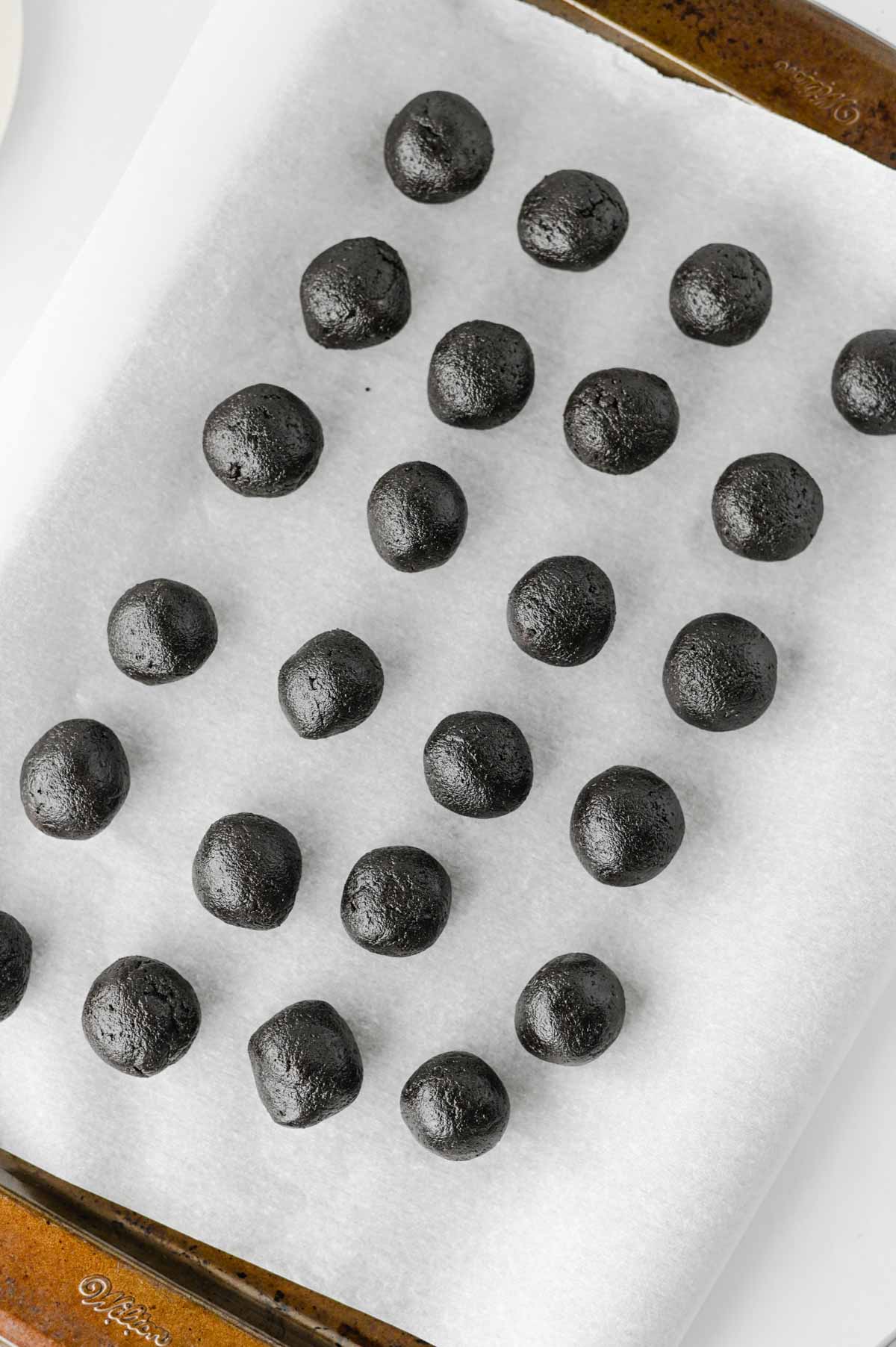 oreo cream cheese balls on a parchment lined baking sheet