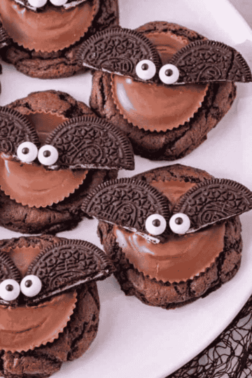 These Reese’s Oreo Bat Cookies are fun Halloween cookies made with chocolate cake mix, Reese’s peanut butter cups, Oreo cookies and candy eyes. These easy Halloween treats are perfect for Halloween parties, classroom treats, spooky dessert trays, fall baking, kids Halloween recipes and cute Halloween desserts. The soft chocolate cookies are topped with peanut butter cups, Oreo bat wings and candy eyes for a creepy cute dessert that looks impressive but is simple to make. Add these Halloween bat cookies to your list of easy Halloween cookie recipes, no stress party desserts, chocolate peanut butter treats and fun Halloween food ideas for kids and adults. They are rich, festive, adorable and perfect for spooky season baking.