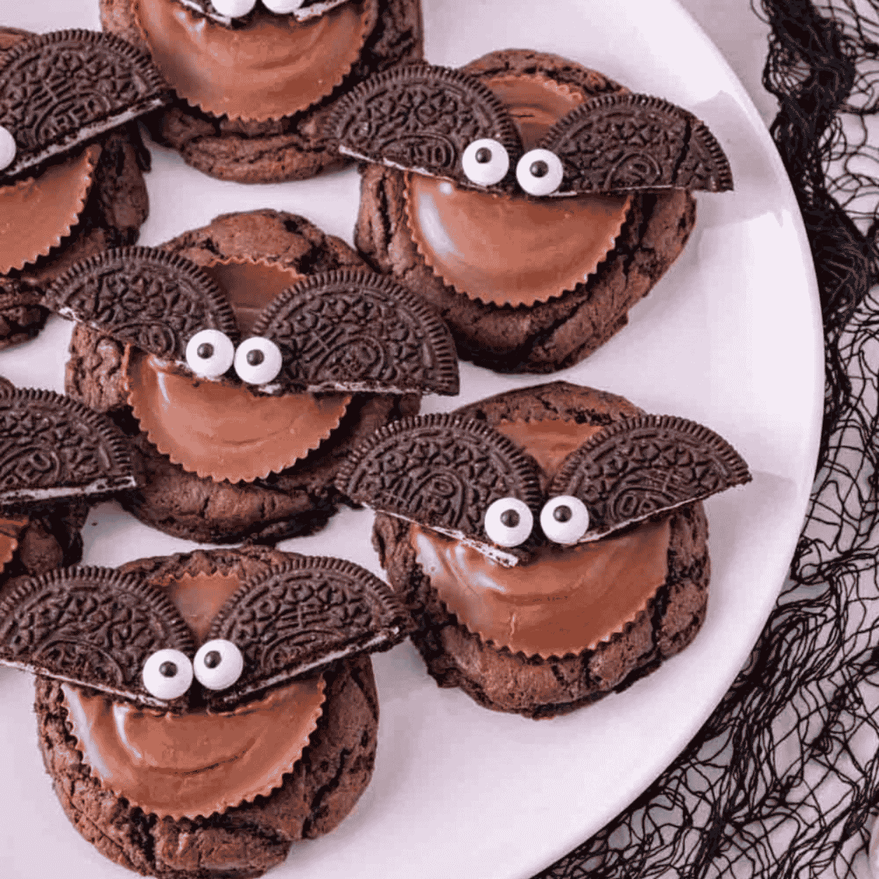 These Reese’s Oreo Bat Cookies are fun Halloween cookies made with chocolate cake mix, Reese’s peanut butter cups, Oreo cookies and candy eyes. These easy Halloween treats are perfect for Halloween parties, classroom treats, spooky dessert trays, fall baking, kids Halloween recipes and cute Halloween desserts. The soft chocolate cookies are topped with peanut butter cups, Oreo bat wings and candy eyes for a creepy cute dessert that looks impressive but is simple to make. Add these Halloween bat cookies to your list of easy Halloween cookie recipes, no stress party desserts, chocolate peanut butter treats and fun Halloween food ideas for kids and adults. They are rich, festive, adorable and perfect for spooky season baking.