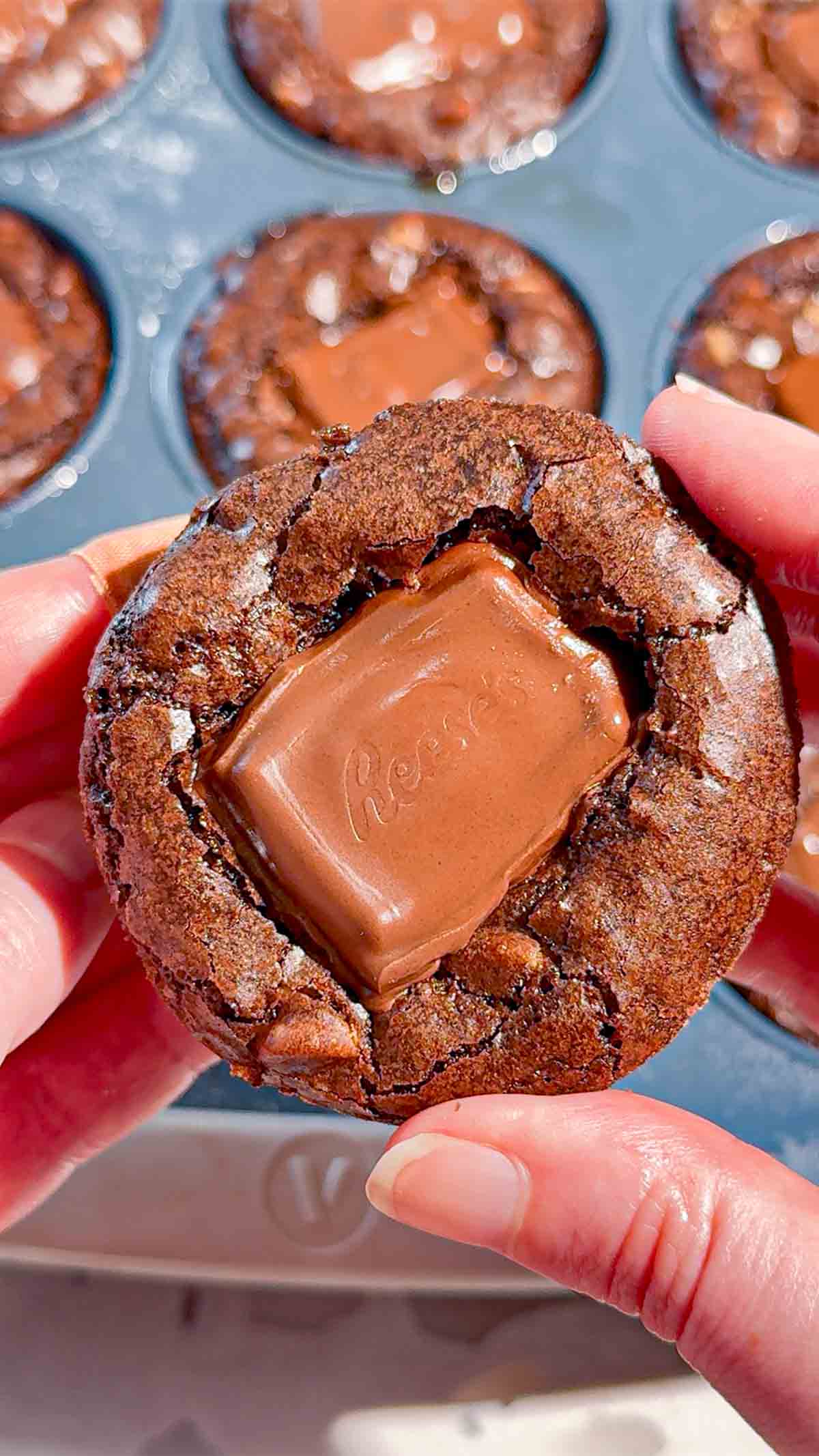 Reese's Stuffed Peanut Butter Brookies are the ultimate dessert for chocolate and peanut butter lovers! These easy muffin tin brookies start with Pillsbury peanut butter cookie dough, then get loaded with Reese's Peanut Butter Cups, Reese's brownie batter and pieces of Reese's peanut butter bar. Ready in just 33 minutes, this easy brookie recipe is perfect for parties, potlucks, holidays or whenever you need an indulgent treat. Save this recipe if you love Reese's desserts, peanut butter cup recipes, brownie cookie desserts, stuffed brookies, easy brownie mix recipes and muffin tin desserts. Every bite has a chewy peanut butter cookie base, a gooey candy center and a fudgy brownie top. These brownie cups are easy to serve and packed with chocolate peanut butter flavor!