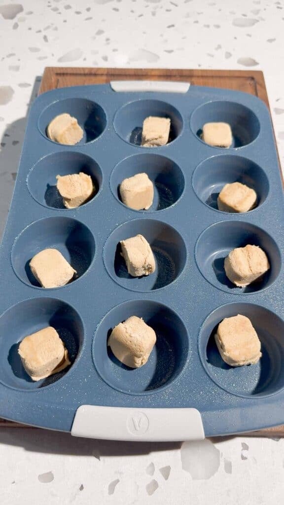 chunks of reese's peanut butter cookie dough in muffin tins