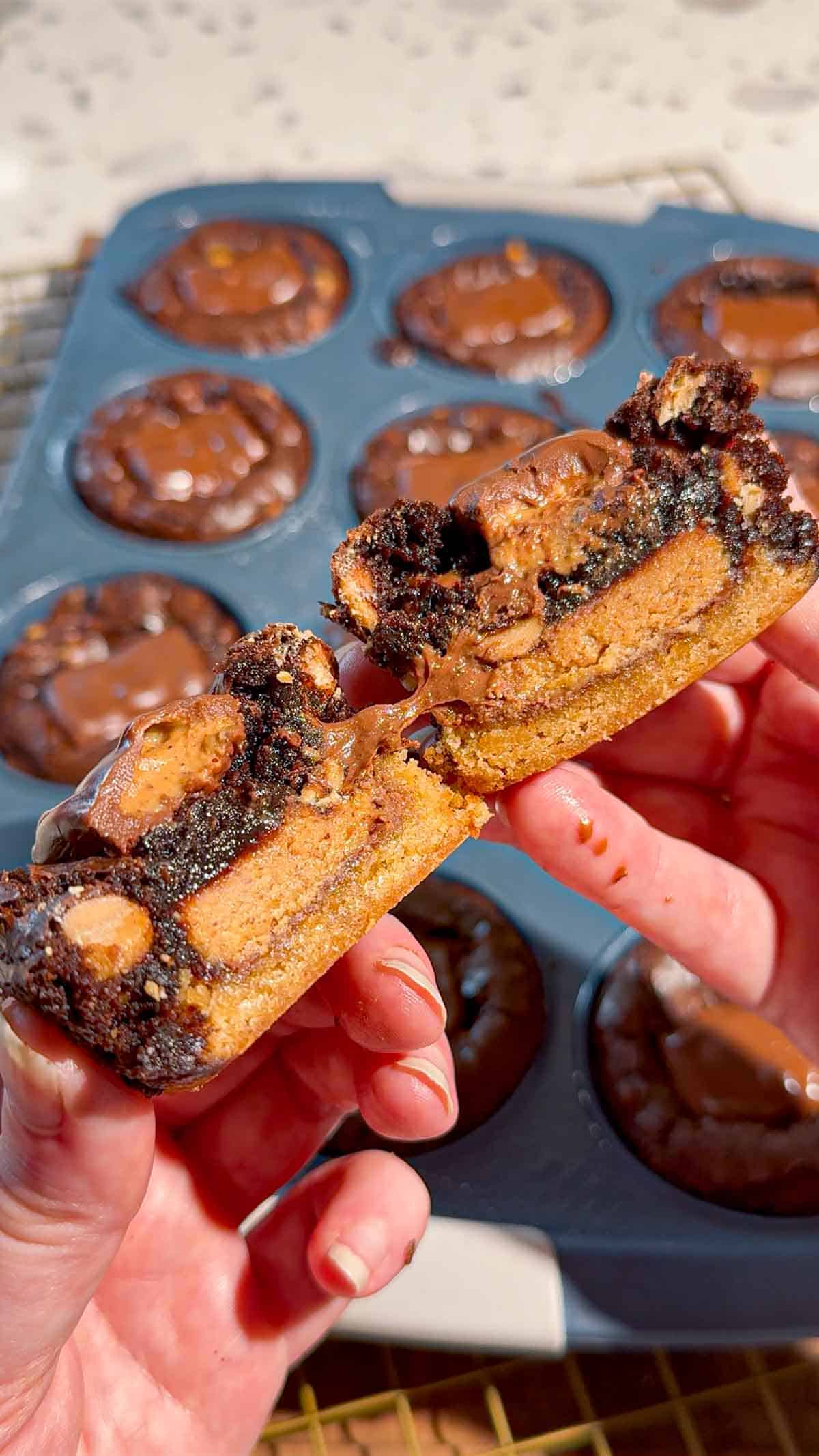Reese's Stuffed Peanut Butter Brookies are the ultimate dessert for chocolate and peanut butter lovers! These easy muffin tin brookies start with Pillsbury peanut butter cookie dough, then get loaded with Reese's Peanut Butter Cups, Reese's brownie batter and pieces of Reese's peanut butter bar. Ready in just 33 minutes, this easy brookie recipe is perfect for parties, potlucks, holidays or whenever you need an indulgent treat. Save this recipe if you love Reese's desserts, peanut butter cup recipes, brownie cookie desserts, stuffed brookies, easy brownie mix recipes and muffin tin desserts. Every bite has a chewy peanut butter cookie base, a gooey candy center and a fudgy brownie top. These brownie cups are easy to serve and packed with chocolate peanut butter flavor!