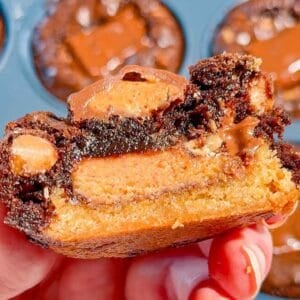 Reese's Stuffed Peanut Butter Brookies are the ultimate dessert for chocolate and peanut butter lovers! These easy muffin tin brookies start with Pillsbury peanut butter cookie dough, then get loaded with Reese's Peanut Butter Cups, Reese's brownie batter and pieces of Reese's peanut butter bar. Ready in just 33 minutes, this easy brookie recipe is perfect for parties, potlucks, holidays or whenever you need an indulgent treat. Save this recipe if you love Reese's desserts, peanut butter cup recipes, brownie cookie desserts, stuffed brookies, easy brownie mix recipes and muffin tin desserts. Every bite has a chewy peanut butter cookie base, a gooey candy center and a fudgy brownie top. These brownie cups are easy to serve and packed with chocolate peanut butter flavor!