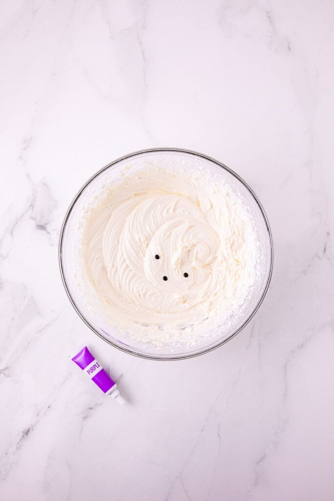 drops of purple food colouring added to cream cheese frosting