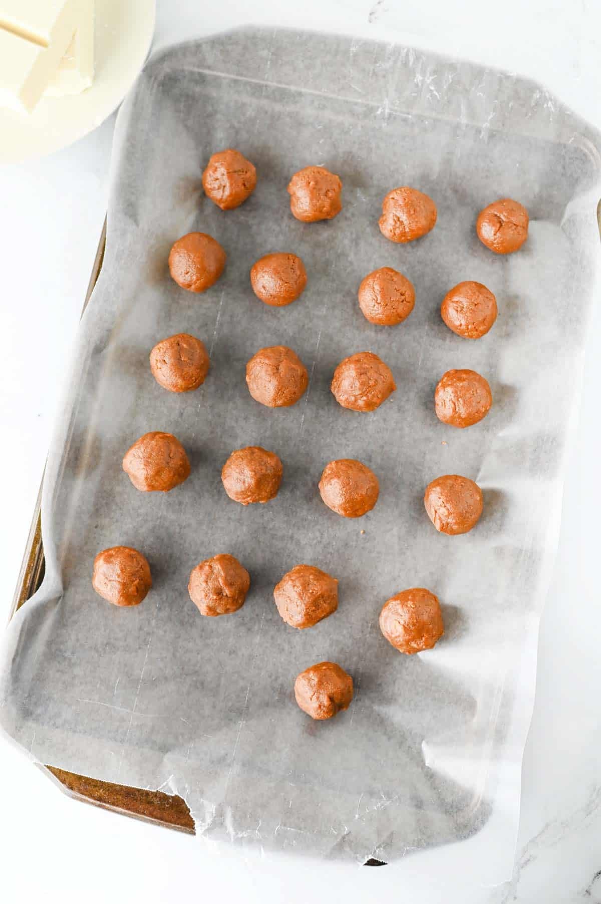 balls of biscoff mixture on a parchment lined baking sheet