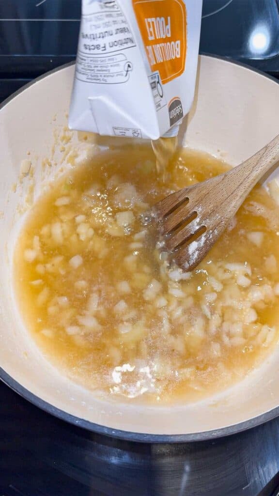 adding chicken broth to pot with flour and onion mixture