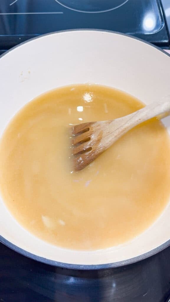 stirring chicken broth in a large pot