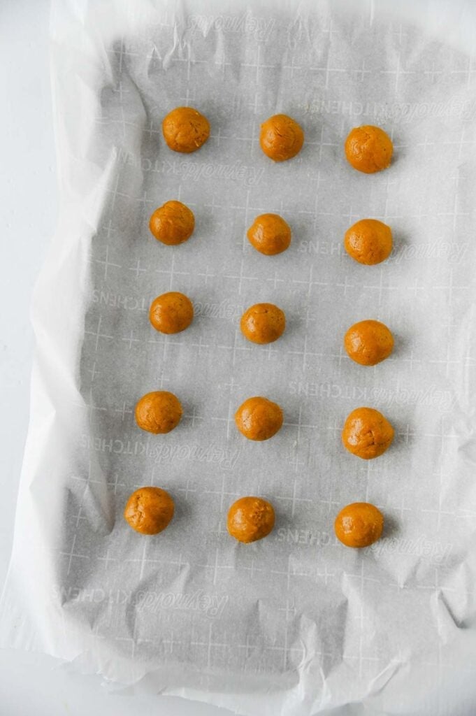 chocolate dipped butterfinger balls on a parchment lined baking sheet