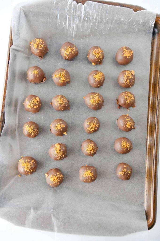 butterfinger balls on a parchment lined baking sheet