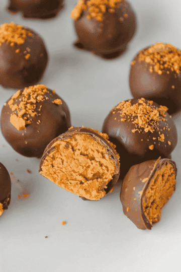 These Butterfinger Balls are an easy no bake dessert made with creamy peanut butter, powdered sugar, graham cracker crumbs, crushed Butterfinger candy and a smooth chocolate almond bark coating. This simple candy recipe is perfect for Christmas dessert trays, holiday parties, cookie exchanges, potlucks, homemade food gifts or an easy make ahead treat for peanut butter lovers. If you need bite sized desserts, chocolate peanut butter balls, Butterfinger candy recipes, no bake Christmas treats, homemade candy ideas or easy party sweets, these crunchy, creamy Butterfinger balls are a fun recipe to save. They set up beautifully, travel well, look great on a dessert platter and deliver that sweet, salty candy bar flavor in every chocolate covered bite.