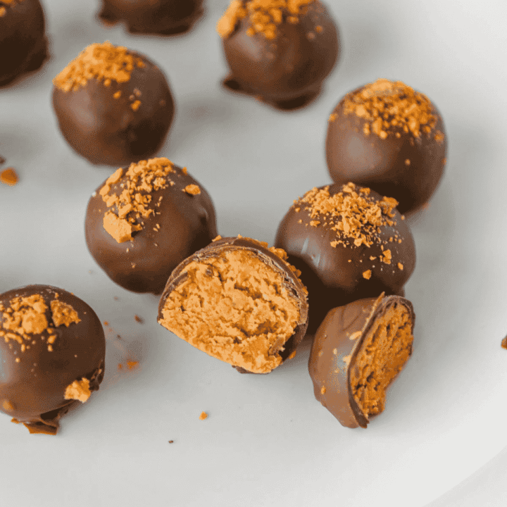 These Butterfinger Balls are an easy no bake dessert made with creamy peanut butter, powdered sugar, graham cracker crumbs, crushed Butterfinger candy and a smooth chocolate almond bark coating. This simple candy recipe is perfect for Christmas dessert trays, holiday parties, cookie exchanges, potlucks, homemade food gifts or an easy make ahead treat for peanut butter lovers. If you need bite sized desserts, chocolate peanut butter balls, Butterfinger candy recipes, no bake Christmas treats, homemade candy ideas or easy party sweets, these crunchy, creamy Butterfinger balls are a fun recipe to save. They set up beautifully, travel well, look great on a dessert platter and deliver that sweet, salty candy bar flavor in every chocolate covered bite.