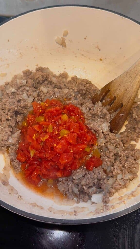 rotel added to pot with cooked ground beef