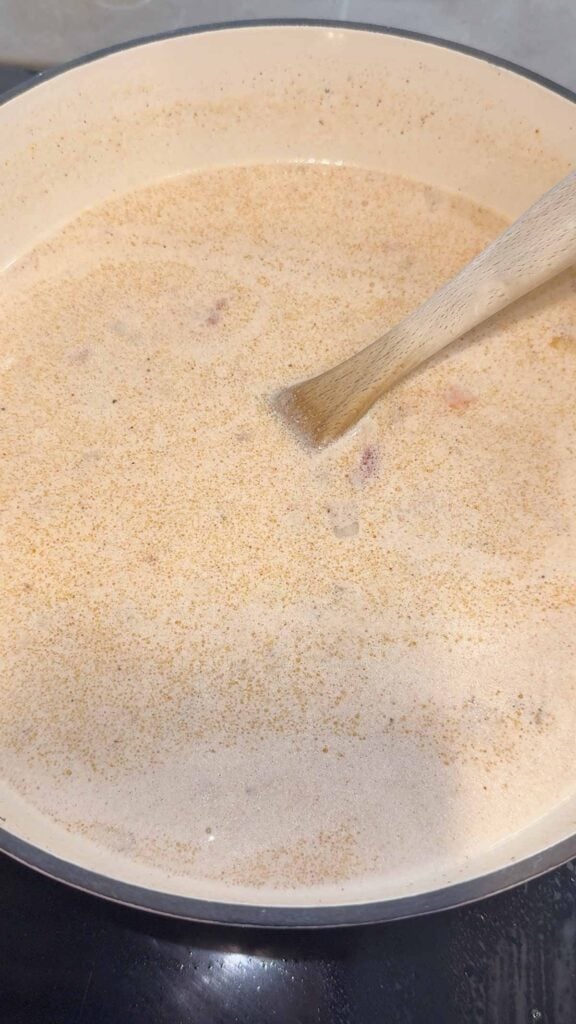creamy soup being stirred in a pot