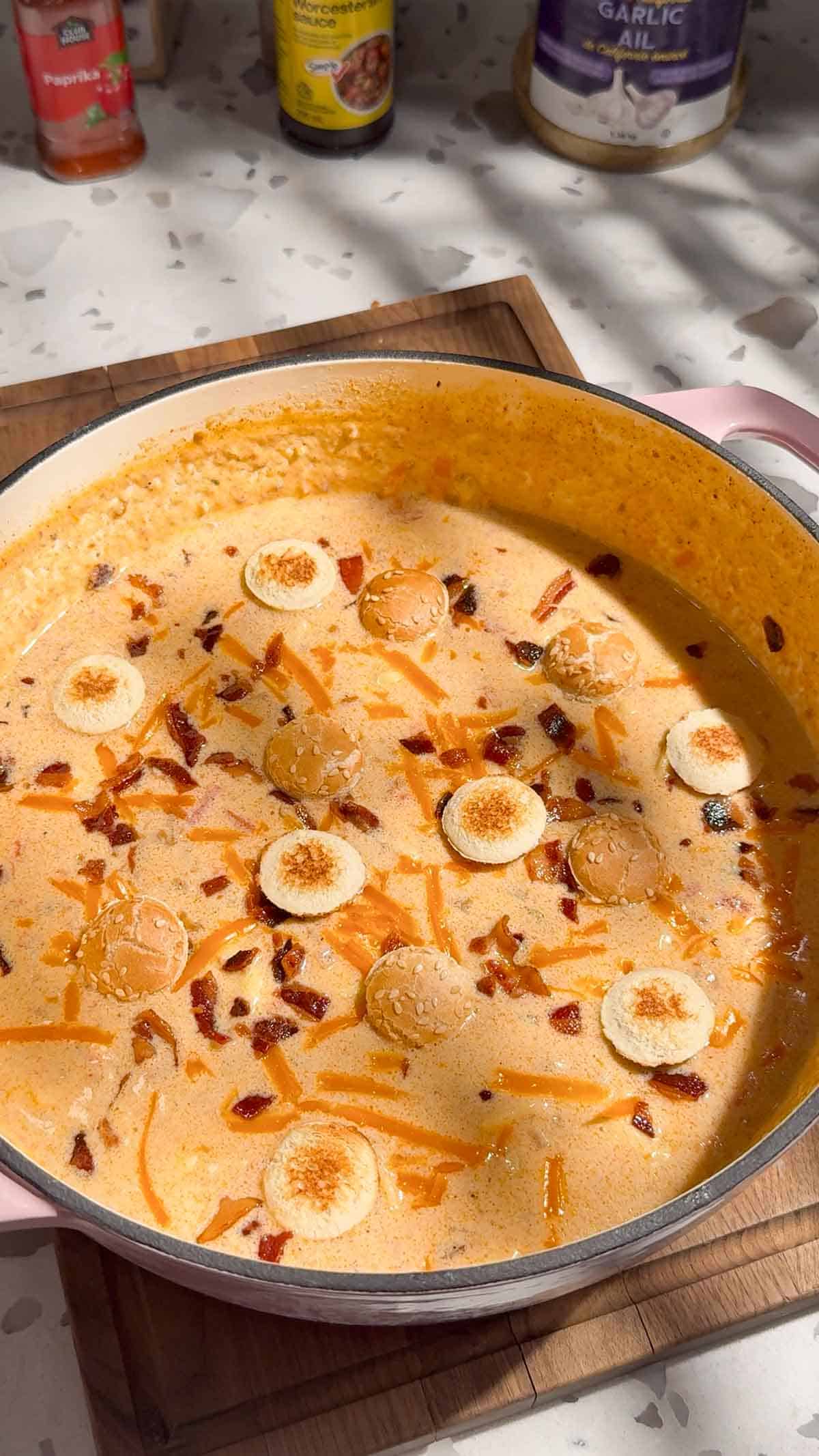 cheeseburger tortellini soup in a pot topped with croutons, bacon and cheddar