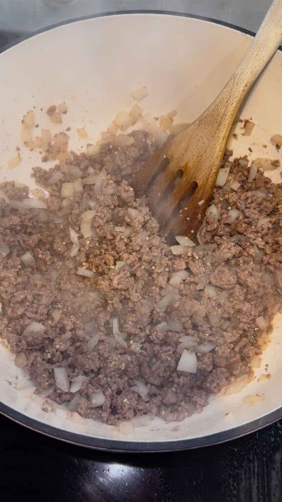cooked ground beef, diced onions and chopped garlic in a pot