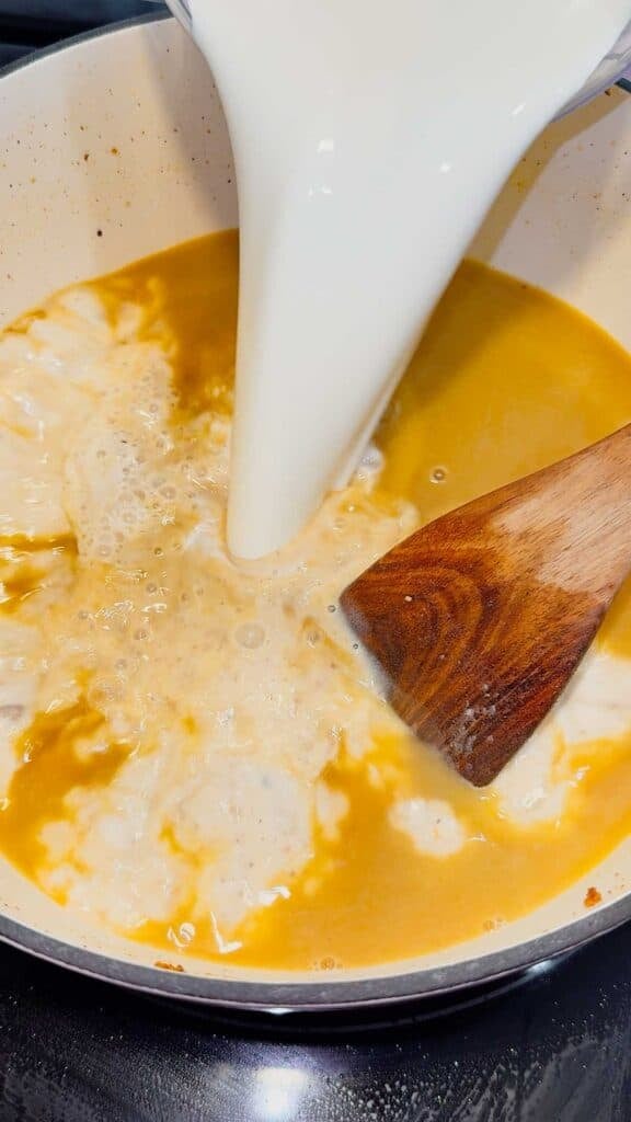 half and half being added to pot with chicken broth mixture