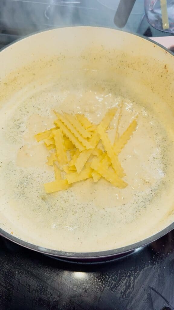 noodles added to pot creamy soup in a pot