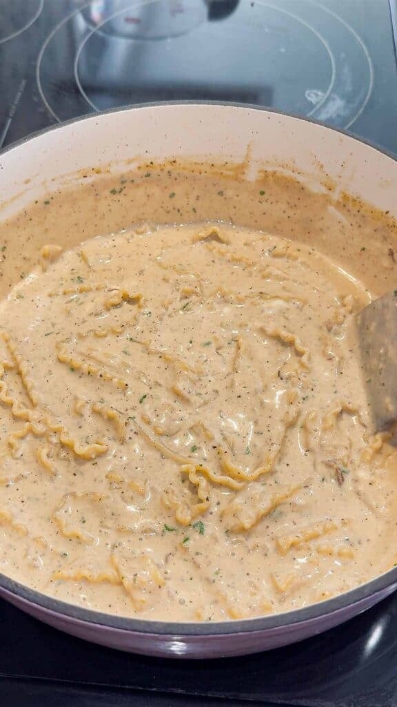 stirring cheese and parsley into creamy lasagna soup