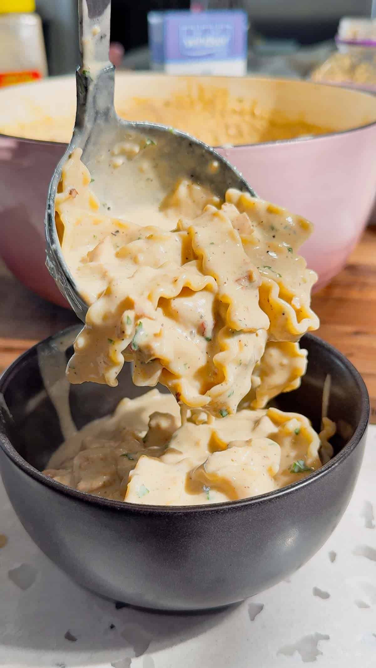 ladling chicken alfredo lasagna soup into a bowl