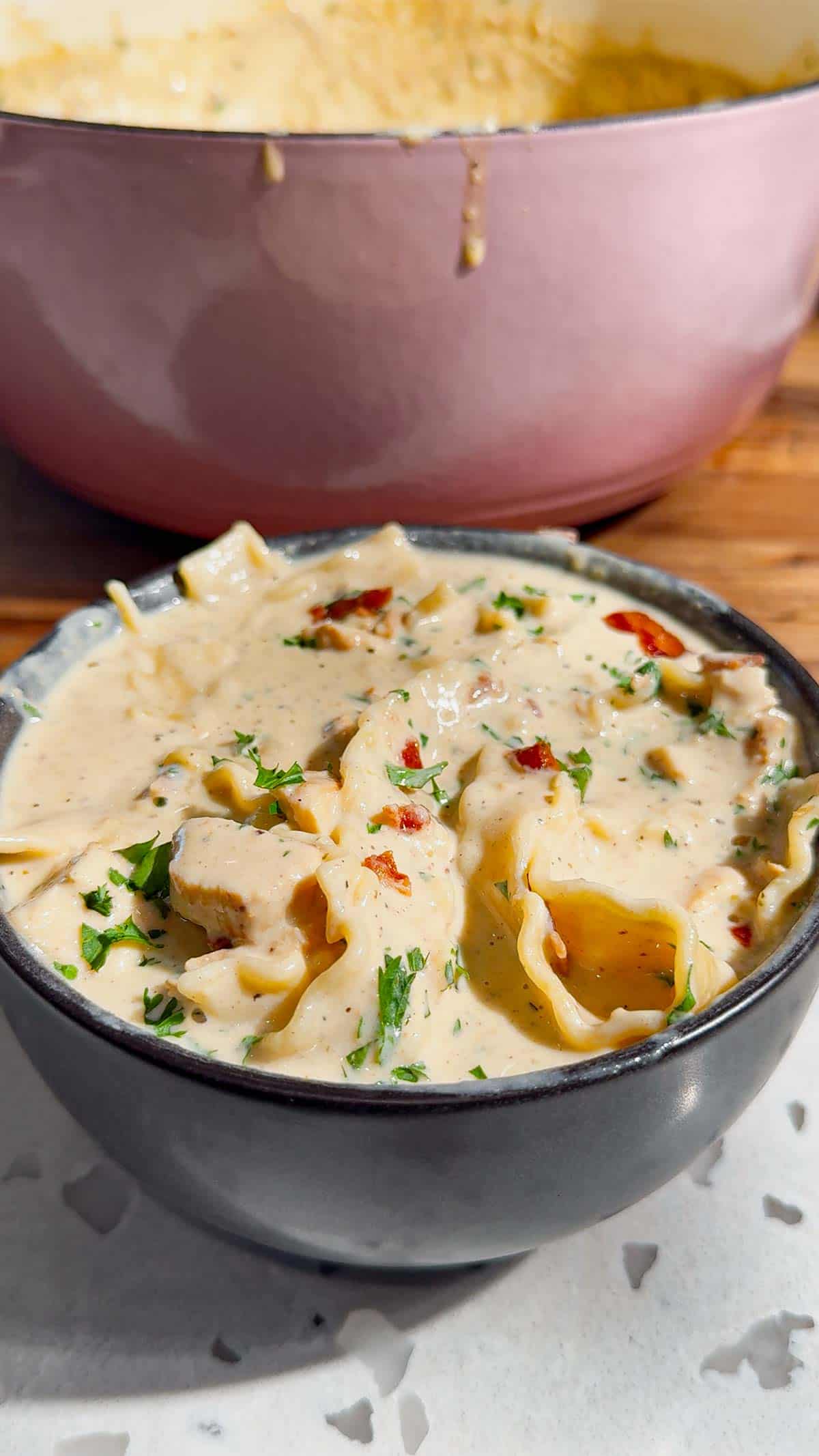 creamy chicken alfredo soup topped with parsley and bacon