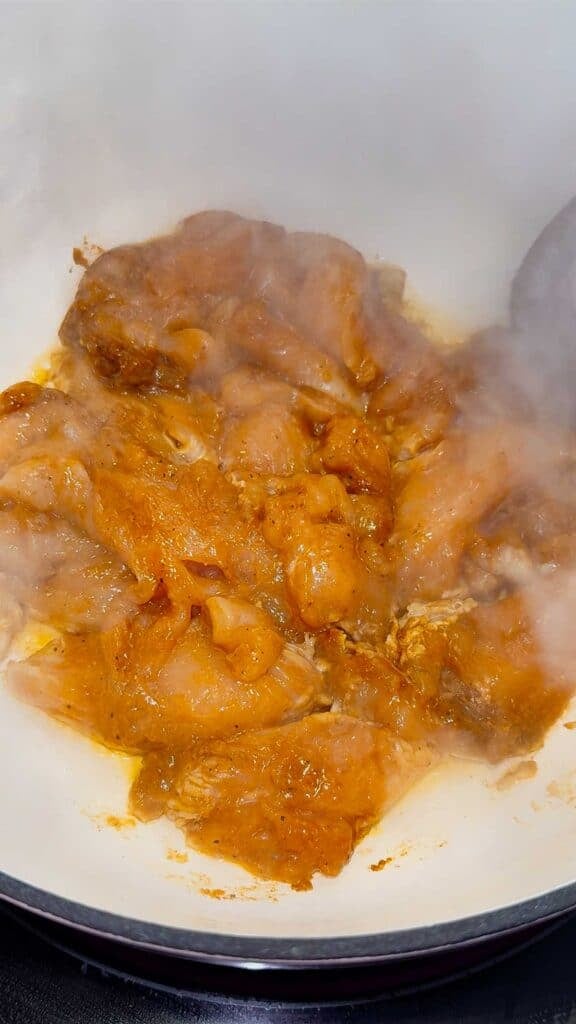 raw seasoned chicken breasts in a dutch oven