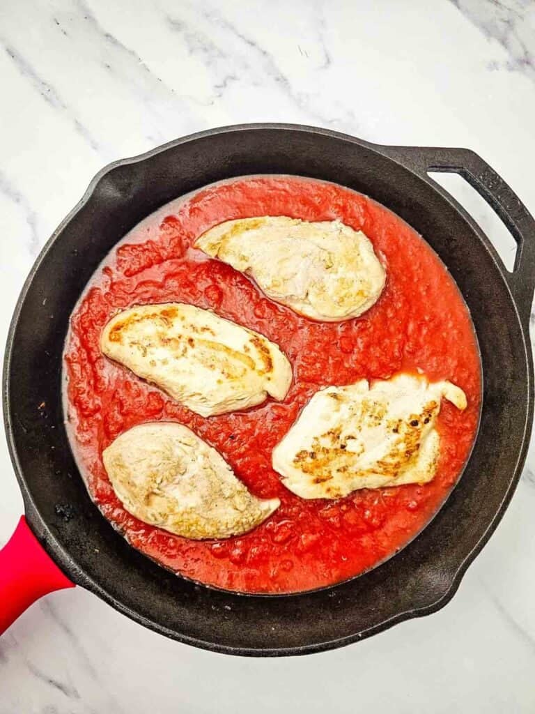 chicken breasts in tomato sauce in a skillet