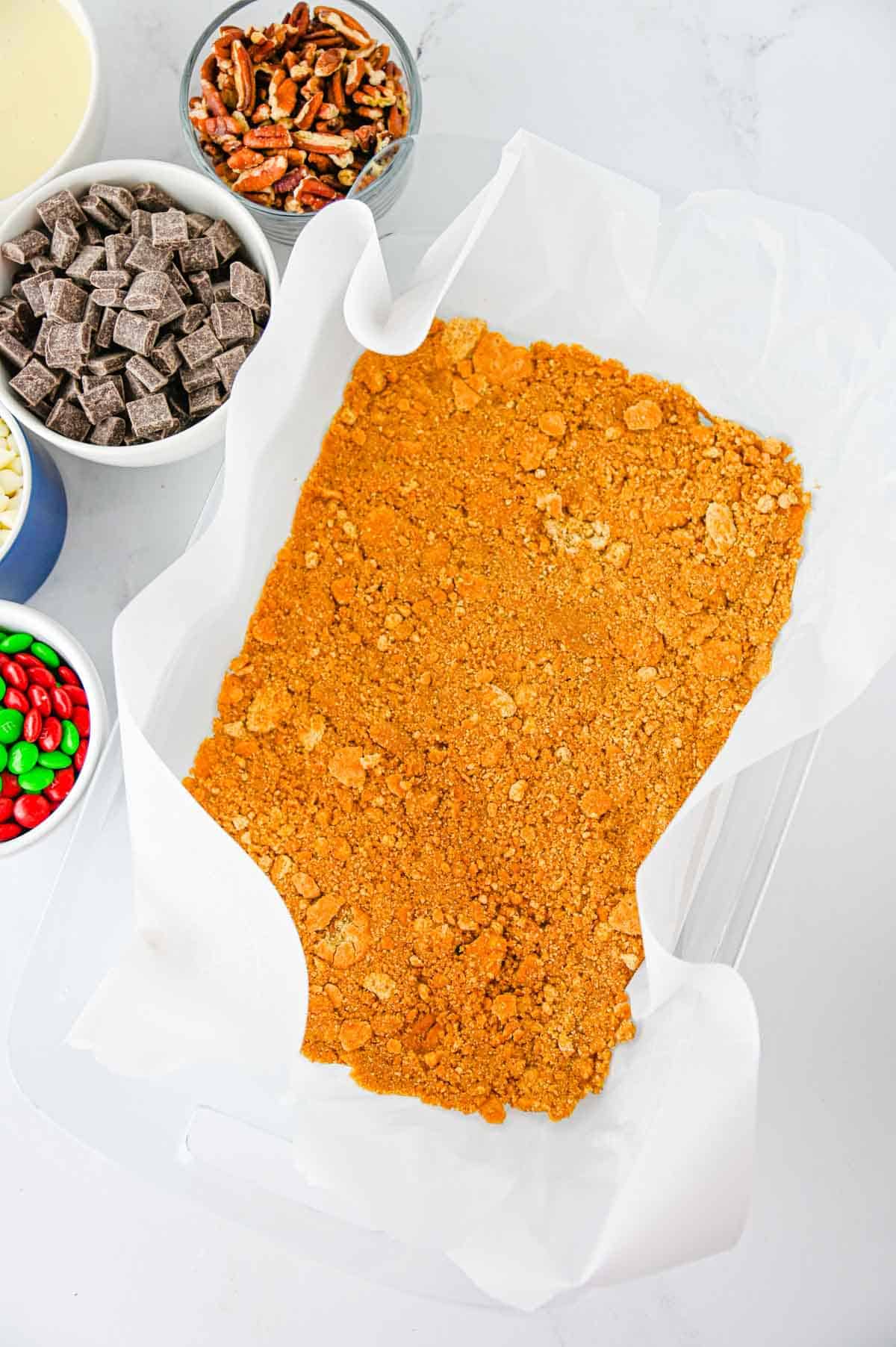 parchment lined baking dish with a graham cracker base