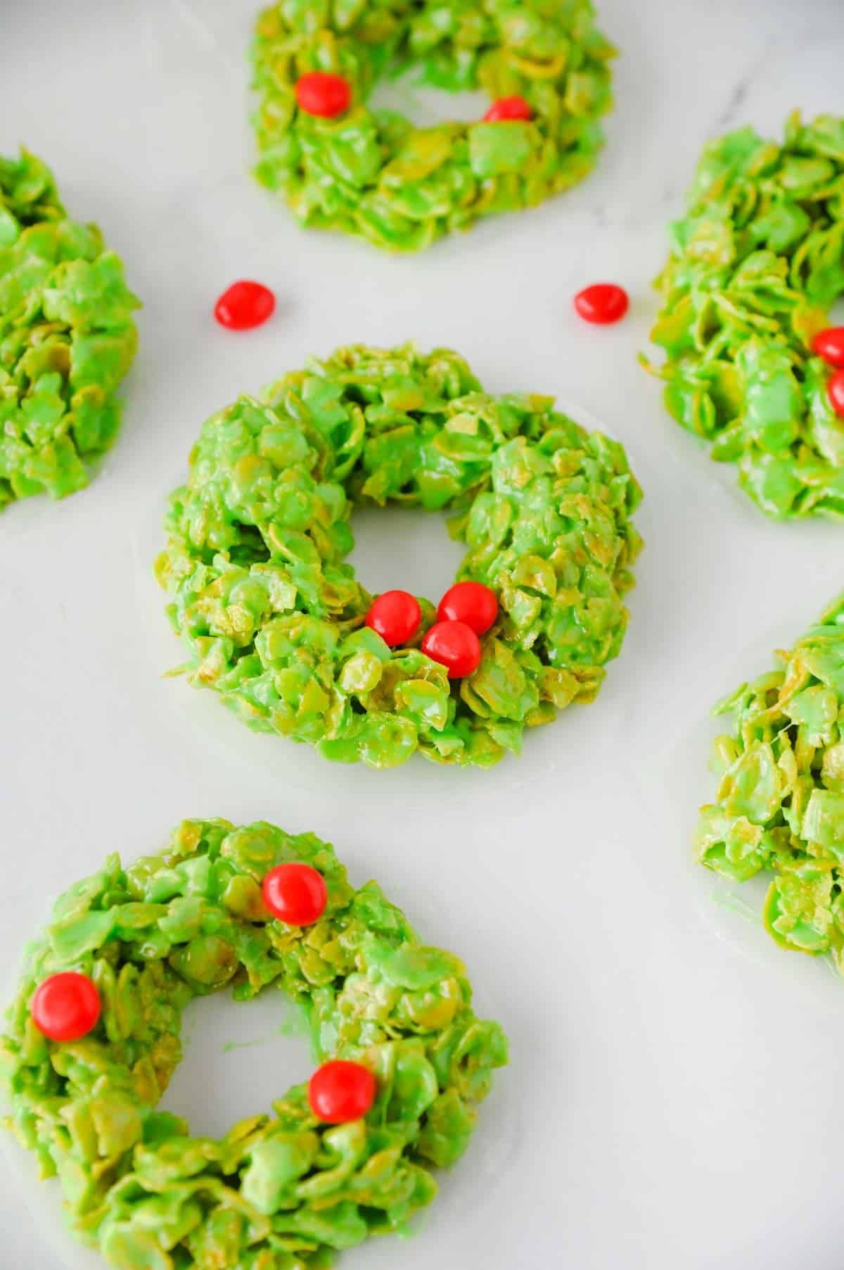 green cornflake wreaths decorated with red hot candies